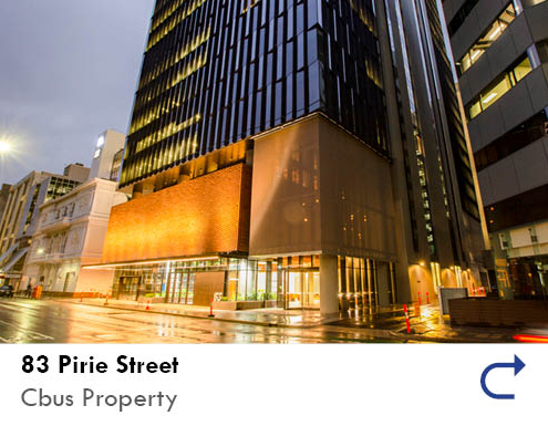 link to the 83 Pirie Street project feature by the Australian National Construction Review. Image of 83 Pirie Street taken at night with a street in the foreground and the building lit up.